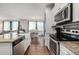 Bright, modern kitchen with stainless appliances and view to the dining room at 9350 Dunraven St, Arvada, CO 80007