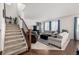 Bright living room with a staircase, plush seating, large windows, and comfortable furnishings at 9350 Dunraven St, Arvada, CO 80007