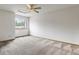 Bright bedroom features a window with tree views, carpet flooring, and a ceiling fan at 2040 Yarrow St, Lakewood, CO 80214