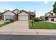 Street view showcasing the home's brick and vinyl exterior, driveway, and small lawn at 2040 Yarrow St, Lakewood, CO 80214