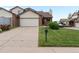 Street view showcasing the home's brick and vinyl exterior, driveway, and small lawn at 2040 Yarrow St, Lakewood, CO 80214