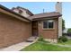 Brick home exterior showing front door and adjacent manicured green lawn at 2040 Yarrow St, Lakewood, CO 80214