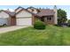 Two-story home with a brick and vinyl exterior, featuring an attached garage and well-maintained lawn at 2040 Yarrow St, Lakewood, CO 80214