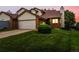 Two-story home with a brick and vinyl exterior, featuring an attached garage and well-maintained lawn at 2040 Yarrow St, Lakewood, CO 80214