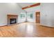 Cozy living room with hardwood floors, a brick fireplace, and large windows at 2040 Yarrow St, Lakewood, CO 80214