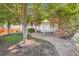 Landscaped backyard with mature trees, rock beds, and a cozy deck at 5191 S Nepal Way, Centennial, CO 80015
