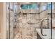 Updated shower features neutral tile, updated fixtures, glass doors, and built in shelving at 5191 S Nepal Way, Centennial, CO 80015