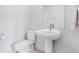 Bathroom featuring a pedestal sink, toilet, and mirror, offering a clean and functional design at 1632 N Gilpin St, Denver, CO 80218