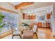 Bright dining area featuring hardwood floors, a modern table, and a view of the updated kitchen at 1632 N Gilpin St, Denver, CO 80218