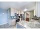 Updated kitchen showcasing stainless steel appliances, granite countertops, and access to the dining area at 6625 S Ogden St, Centennial, CO 80121