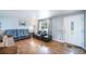 An open-concept living room featuring hardwood floors, modern furniture, and a decorative front door at 6625 S Ogden St, Centennial, CO 80121