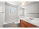 Bathroom with a tub and shower combination, wood vanity, and window for natural light at 3298 W 11Th Avenue Pl, Broomfield, CO 80020