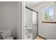 Bathroom with a marble-tiled shower, a toilet, and a window that lets in natural light at 3298 W 11Th Avenue Pl, Broomfield, CO 80020
