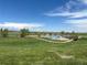 Picturesque view of grassy community grounds, pond, and walking path, ideal for nature lovers and outdoor activities at 3298 W 11Th Avenue Pl, Broomfield, CO 80020