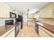 Traditional kitchen featuring light cabinets, black appliances, and wood flooring for a warm, inviting feel at 3298 W 11Th Avenue Pl, Broomfield, CO 80020