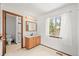 Main bathroom with wood cabinets, tiled walk-in shower, large window with white curtain and natural light at 3298 W 11Th Avenue Pl, Broomfield, CO 80020