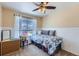 Inviting bedroom with a floral comforter, chair rail detail, and a ceiling fan at 1201 Trout Creek Cir, Longmont, CO 80504