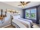 Comfortable bedroom features a ceiling fan, a large window, and airplane-themed wall art at 1201 Trout Creek Cir, Longmont, CO 80504
