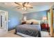 Bright bedroom featuring a ceiling fan, matching red nightstands, and two lamps at 1201 Trout Creek Cir, Longmont, CO 80504