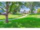 Expansive grassy park with a bench and walking path, shaded by mature trees at 1201 Trout Creek Cir, Longmont, CO 80504
