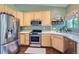 Bright kitchen features stainless steel appliances, sleek countertops, light wood cabinets, and hardwood floors at 1201 Trout Creek Cir, Longmont, CO 80504