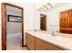 Bathroom with double sinks, wood cabinets, and a tub with shower in the background at 4 Oakmont Ln, Littleton, CO 80127