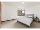 Cozy bedroom with soft carpet, a comfortable bed, and a serene view from the bay window at 4 Oakmont Ln, Littleton, CO 80127