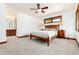 Well-lit bedroom with a ceiling fan, wood-trimmed windows, carpeted floors, and access to a sink area at 4 Oakmont Ln, Littleton, CO 80127