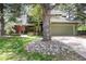 Charming two-story home with a two-car garage and lush landscaping, including a large tree at 4 Oakmont Ln, Littleton, CO 80127