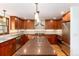 Modern kitchen with stainless steel appliances, brown cabinets, and an island at 4 Oakmont Ln, Littleton, CO 80127