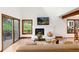 Living room with fireplace, comfortable sofa, and serene outdoor views through large windows at 4 Oakmont Ln, Littleton, CO 80127