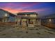 Inviting backyard with covered patio and fenced yard, enhanced by a colorful sunset backdrop at 892 High Point Trl, Elizabeth, CO 80107