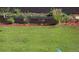 Backyard featuring a well-maintained lawn, garden beds, and brick retaining wall at 892 High Point Trl, Elizabeth, CO 80107