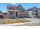 Charming two-story home featuring stone accents, a covered porch, a two-car garage, and a well-manicured lawn at 892 High Point Trl, Elizabeth, CO 80107