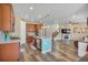 Spacious open kitchen with stainless steel appliances, an island, and seamless flow into the living area and staircase at 892 High Point Trl, Elizabeth, CO 80107