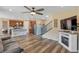 Spacious living area with fireplace, open kitchen, stairs, and wood flooring at 892 High Point Trl, Elizabeth, CO 80107