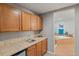 A kitchenette/bar area adjacent to a full bathroom, with oak cabinets, tile backsplash, a sink and room for a mini-fridge at 1609 S Catawba Cir, Aurora, CO 80018