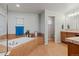 Bright bathroom features a soaking tub with tile surround, with views of the sink, and a separate toilet area at 1609 S Catawba Cir, Aurora, CO 80018