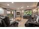 Cozy living room features a fireplace, plush carpet, leather seating, and access to a covered patio at 1609 S Catawba Cir, Aurora, CO 80018