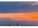 A plane flies in the sunset, painting the mountains in the distance with orange and pink light at 1609 S Catawba Cir, Aurora, CO 80018