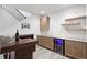 Basement bar with wood cabinets, bar shelves and a wine cooler at 4745 Mesa Top Dr, Monument, CO 80132