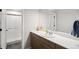 Bright bathroom featuring wood cabinets, a walk-in shower, and a large mirror at 4745 Mesa Top Dr, Monument, CO 80132