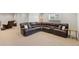 Spacious living room with a large brown leather sectional, and neutral carpeting at 4745 Mesa Top Dr, Monument, CO 80132