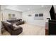 Large living room with a brown sectional, multiple windows, and neutral walls and carpeting at 4745 Mesa Top Dr, Monument, CO 80132