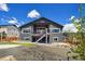 Back of the property showcasing the private yard with stairs to the second-story deck and gravel landscaping at 4745 Mesa Top Dr, Monument, CO 80132