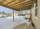 Covered patio area in the backyard with snow on the ground at 8501 E 104Th Ave, Henderson, CO 80640