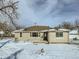 Tan house with dark door, snow covered yard at 8501 E 104Th Ave, Henderson, CO 80640