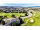 Breathtaking aerial showcases homes in a golf course community, with lush greens and scenic views of the mountains at 3383 Mount Royal Dr # 46, Castle Rock, CO 80104