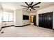 A bedroom features carpet flooring, black trim, a ceiling fan, and closet doors at 3383 Mount Royal Dr # 46, Castle Rock, CO 80104