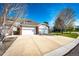 Two-story home with a large concrete driveway, green lawn, mature trees, and a two-car garage at 3383 Mount Royal Dr # 46, Castle Rock, CO 80104